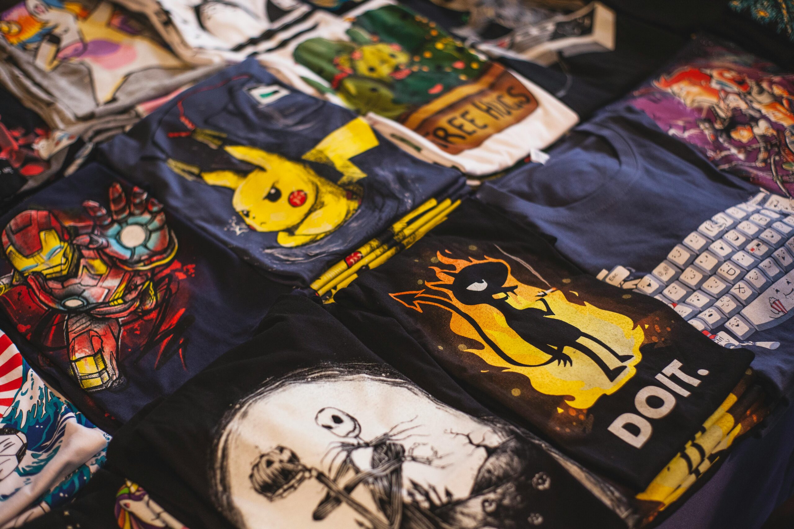 A vibrant assortment of graphic t-shirts featuring popular characters displayed in a market setting.